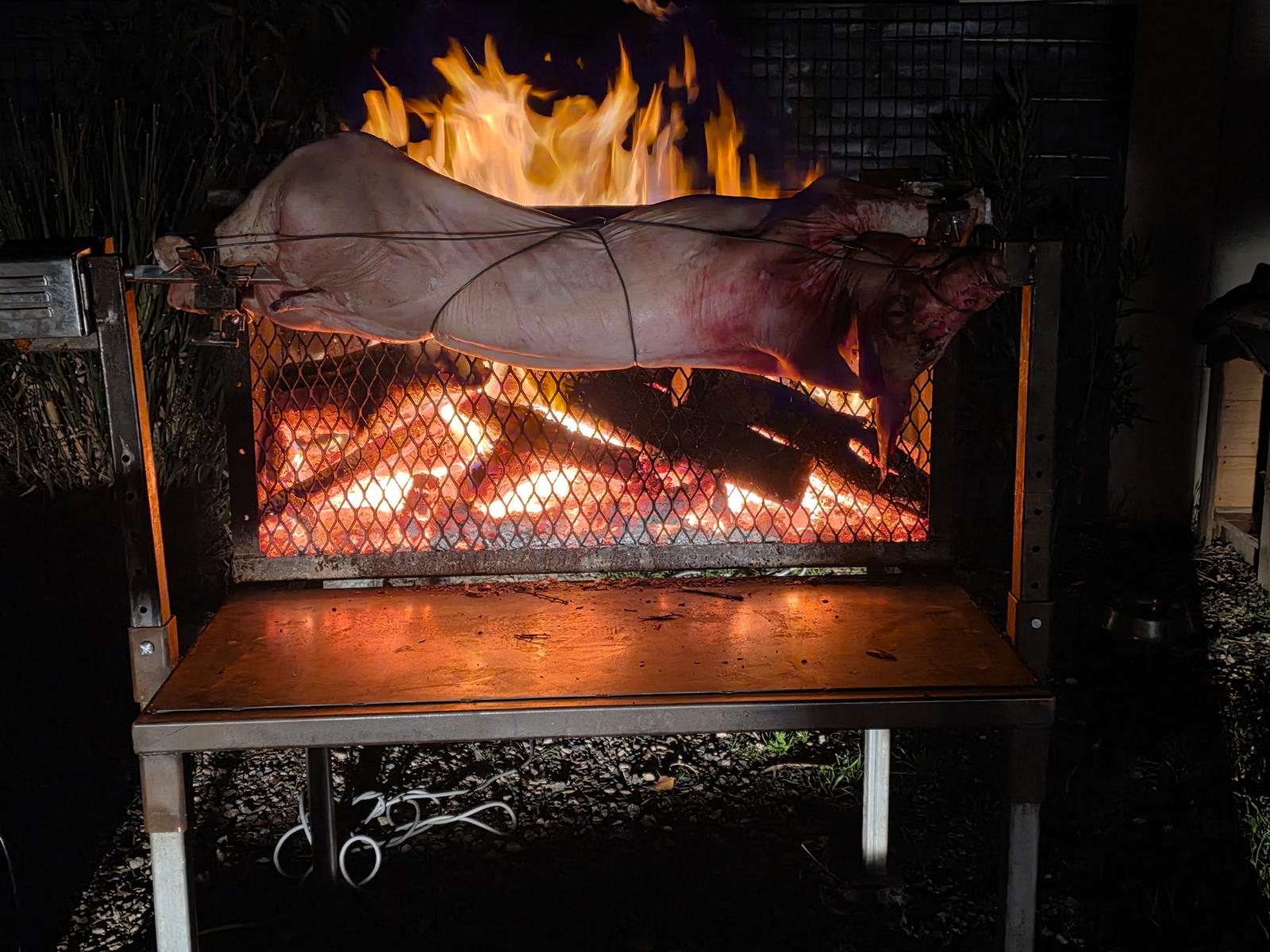 Cochon entier à la broche et flammes intenses au feu de bois